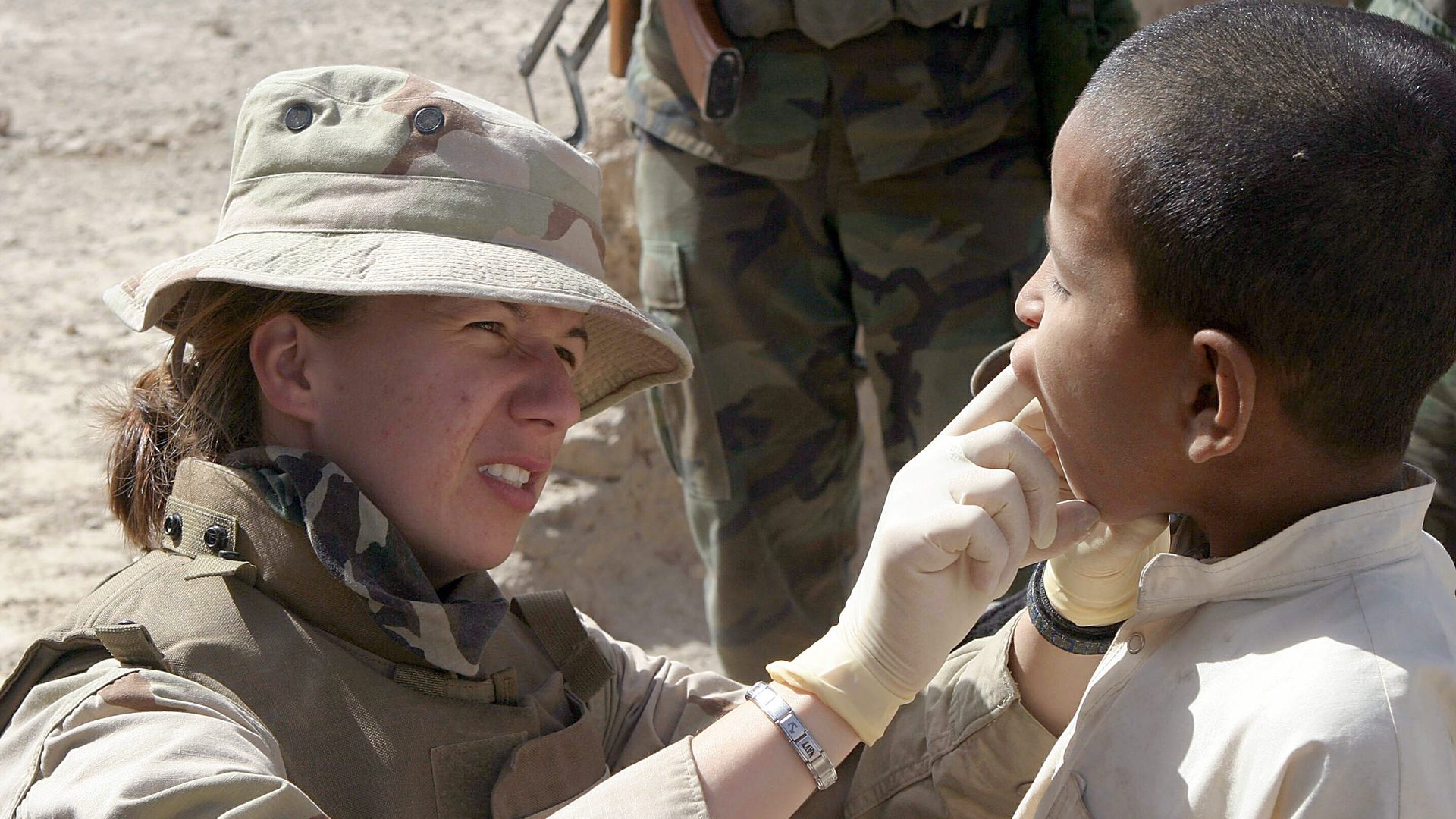 US Navy 040422-M-8096M-015 U.S. Navy Lt. Amy Plant, a Navy dentist, examines the teeth and gums of a young Afghan boy during a Coalition med